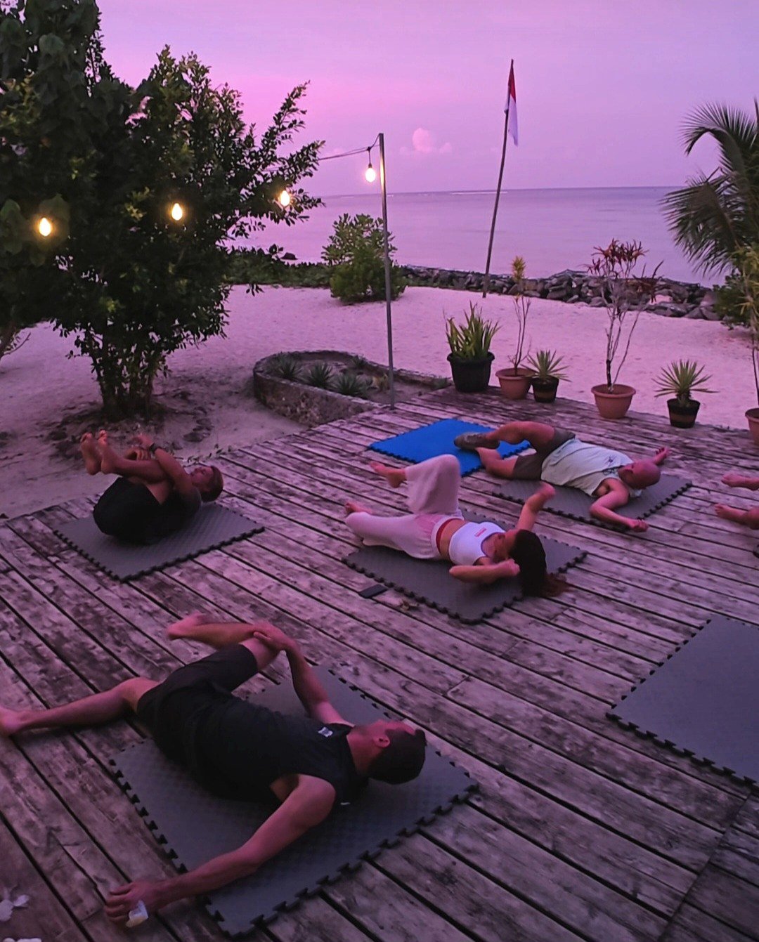 A real group mobility session on mats by the ocean at sunset
